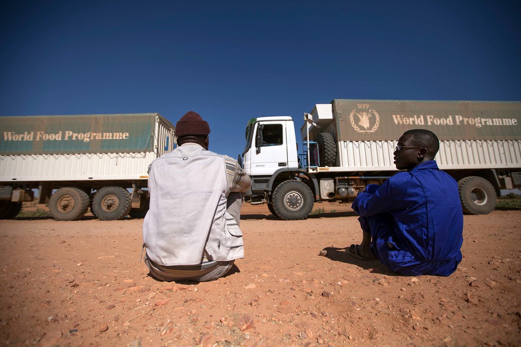 WFP food distribution 10 February 2014. El Fasher: Two World Food Programme (WFP) truck drivers rest while waiting their colleagues to change a flat tire from one of the vehicles of the convoy traveling from El Fasher to Shangil Tobaya, North Darfur.