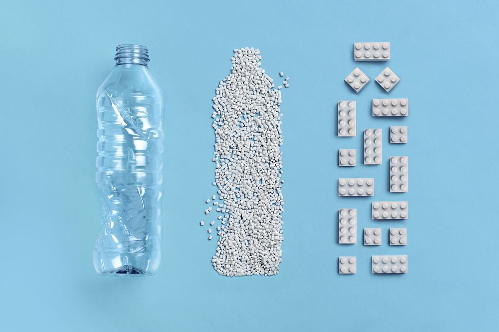 A plastic bottle, granulated PET in the shape of a bottle, LEGO bricks made from recycled PET in the shape of a bottle.