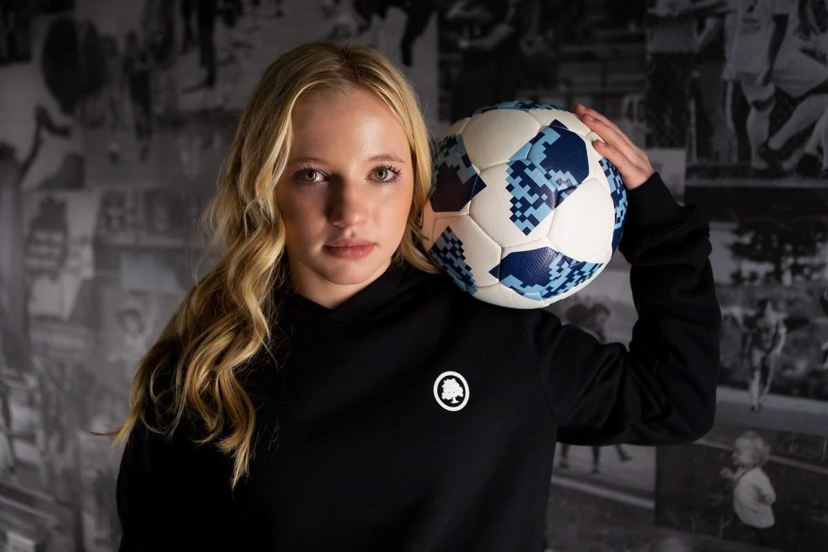 Chloe Ricketts holding soccer ball on her shoulder at age 14 on signing with AFC Ann Arbor in 2022.