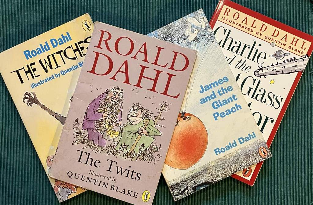 A picture showing four paperback copies of books by Roald Dahl: The Twits, James and the Giant Peach, Charlie and the Great Glass Elevator, and The Witches.