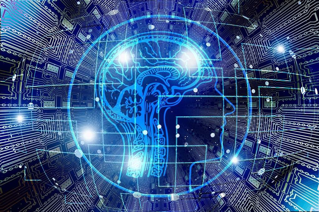 An image purporting to illustrate artificial intelligence. It shows an outline of a human head with the brain visible, inside a circle surrounded by circuit boards.