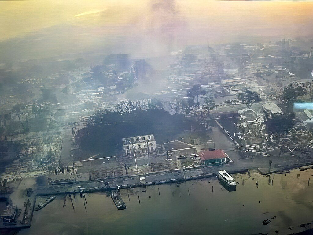 Flyover photo by the US Civil Air Patrol showing damage to the West Maui town of Lahaina and harbor on Wednesday, August 9. The ground is covered with destroyed buildings and the air is thick with smoke.