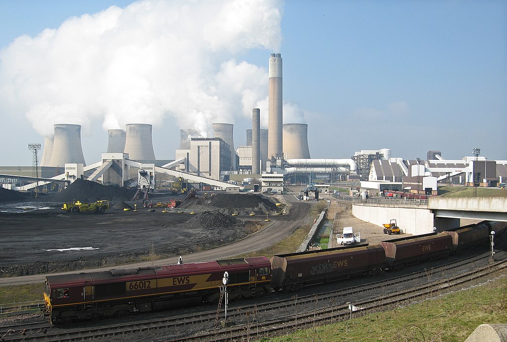 Ratcliffe-on-Soar power station, from the east, with a train of coal being unloaded as it passes at walking pace through the building at middle right.