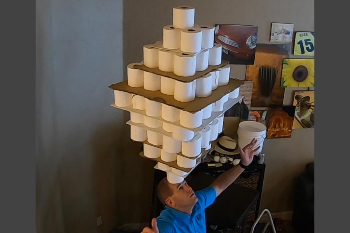 David Rush sets the world record for balancing the most rolls of toilet paper - 101 - on his head.